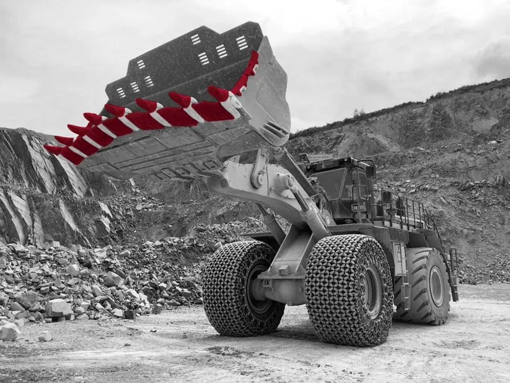 Wheel loader lifting a bucket fitted with MTG teeth in a quarry