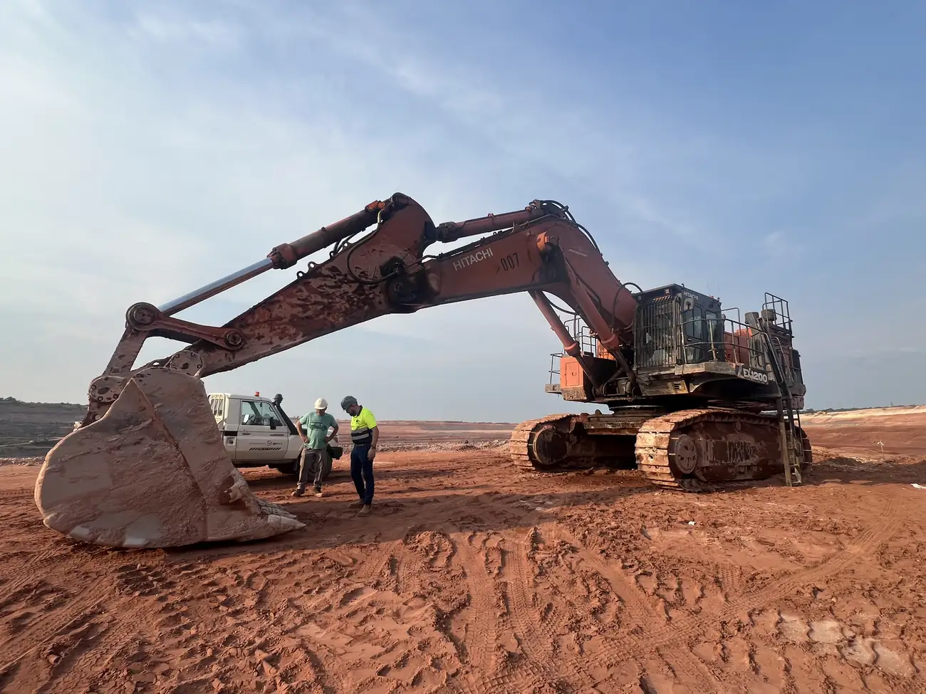 Excavator digging red earth on a mining site